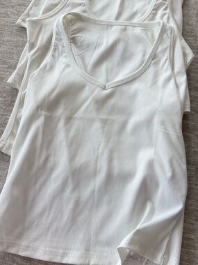 Lot of 4 white tank tops.